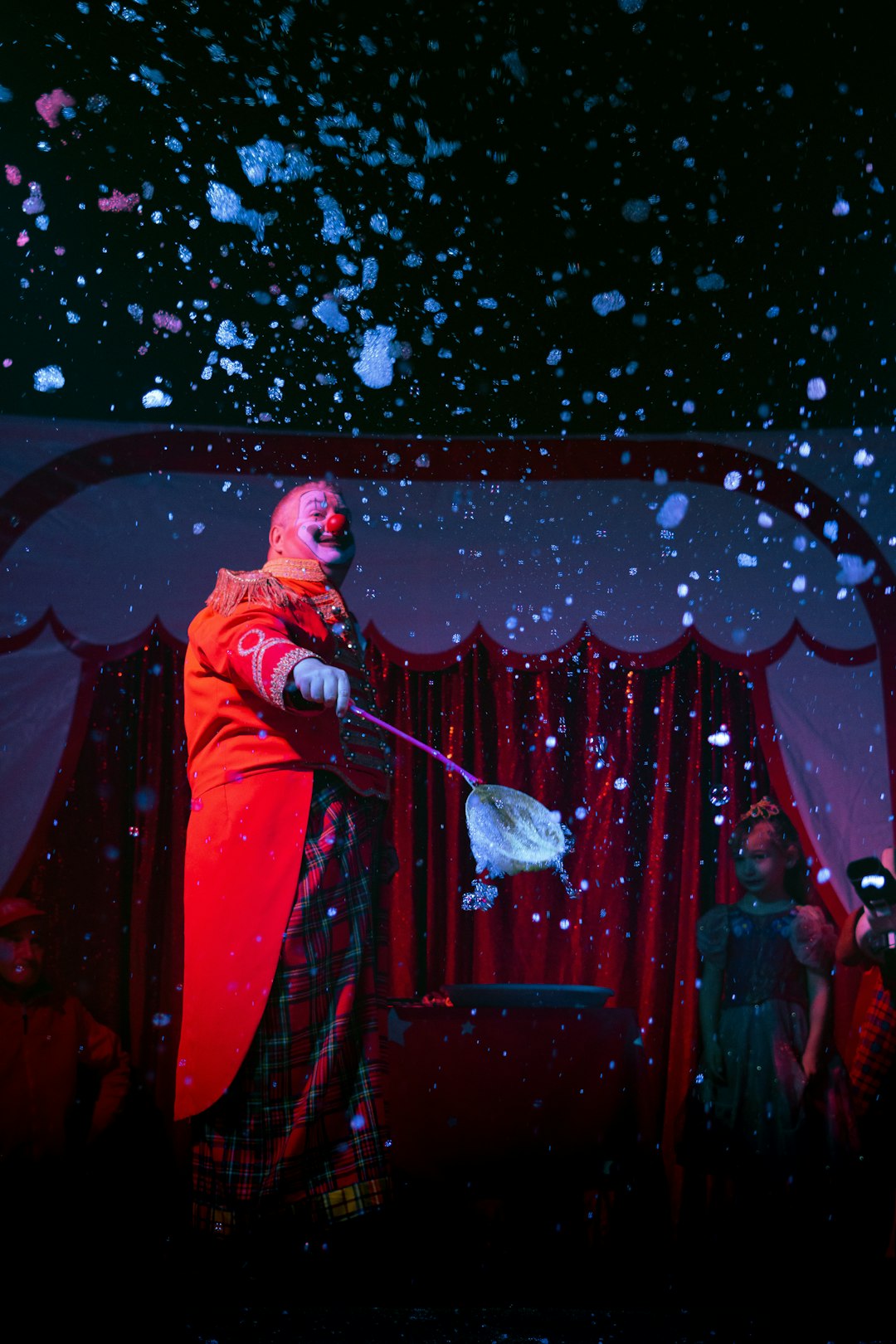 a-man-in-a-clown-costume-juggling-water-on-a-stage-oyaadewba3a